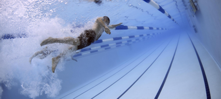 person swimming under water in pool swim lane